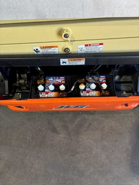 Battery tray swung open on the JLG 1930ES showing the new batteries and cabling