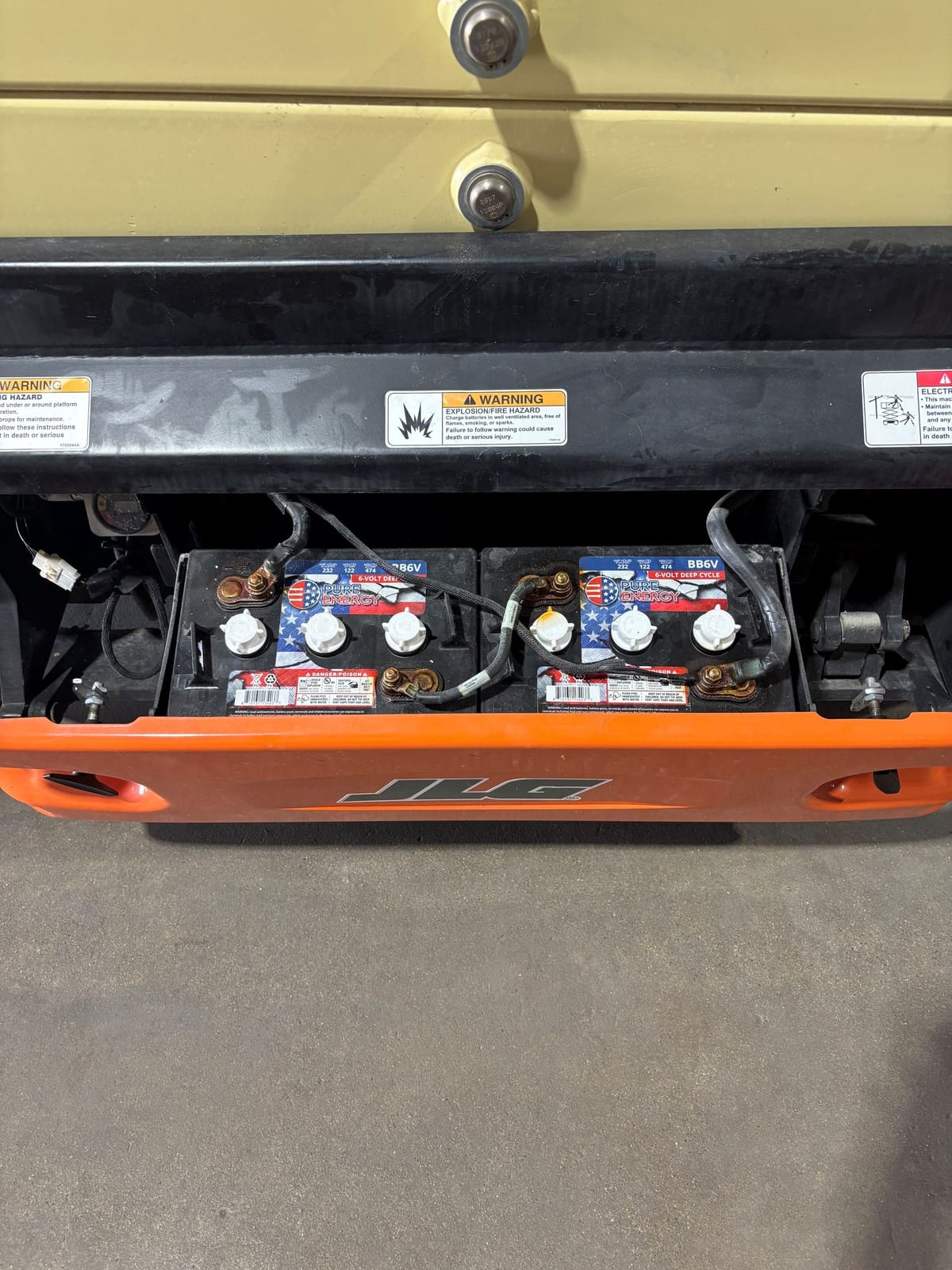 Battery tray open on the JLG 3246ES showing the new batteries and cabling