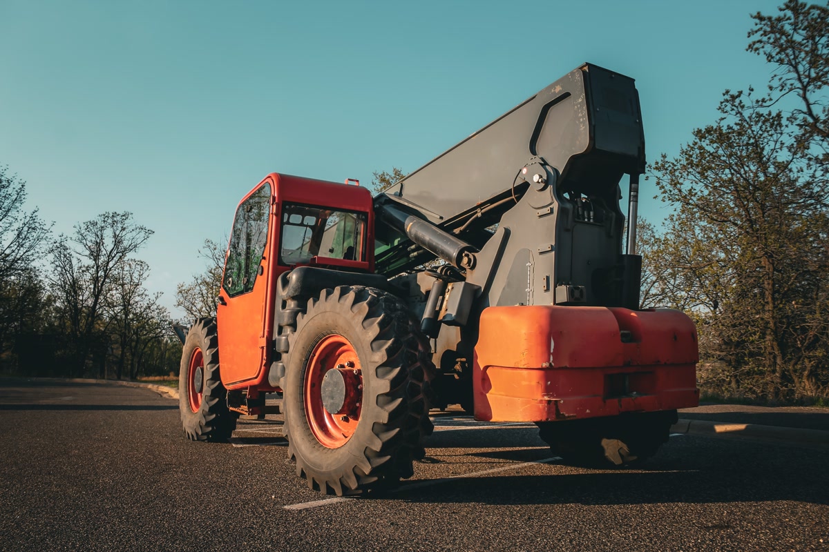 A telehandler parked on asphalt at sunset