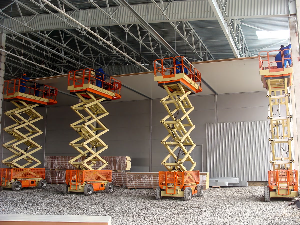 Scissor lifts raised inside a warehouse during panel installation